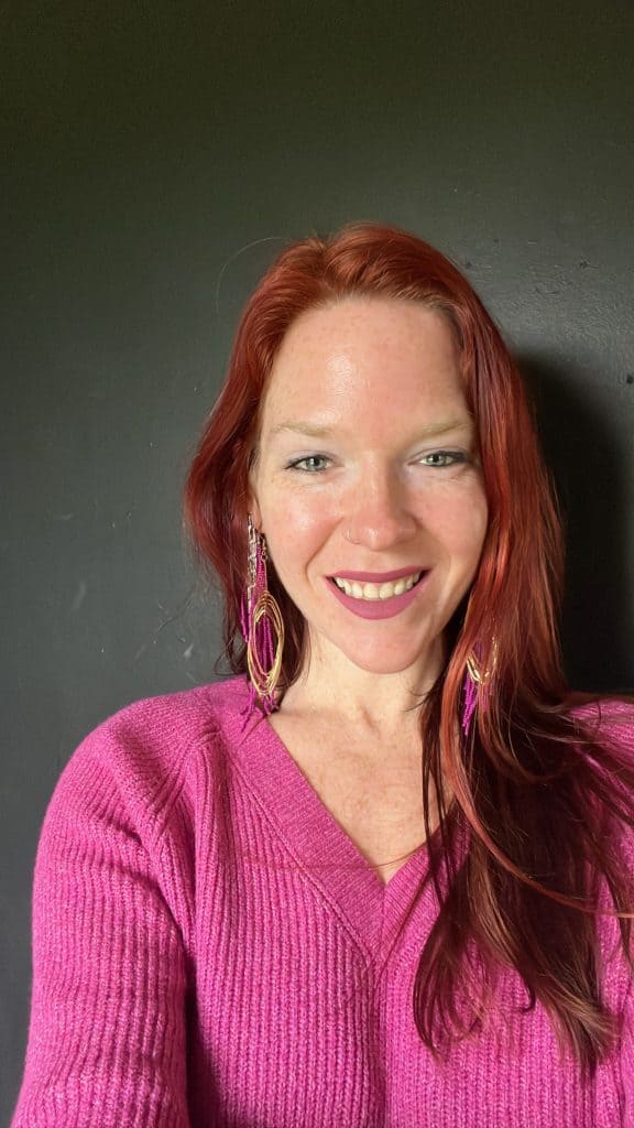Rach smiling in a pink sweater